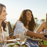 Three female friends enjoying dinner outside